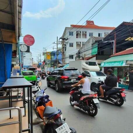 Soi Buakhao Pattaya bei Tag Belebte Soi Buakhao in Pattaya mit Autos, Motorrädern, Bars und Geschäften entlang der Straße