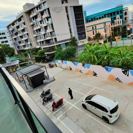 Warten auf Bolt am SRINN Hotel Pattaya Klang Parkplatz am SRINN Hotel Pattaya Klang mit Scootern und Auto als möglichem Abholpunkt für Bolt