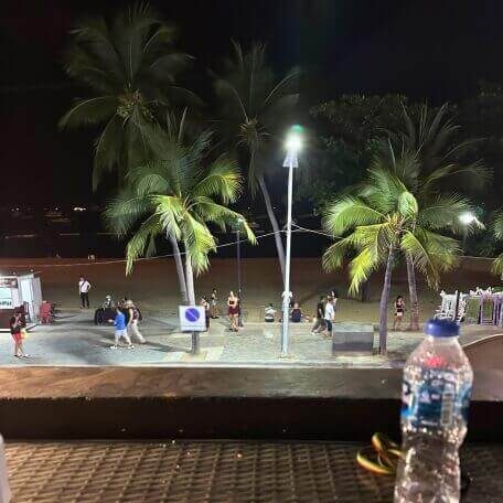 Beach Road in Pattaya bei Nacht mit Palmen, Promenade und Passanten