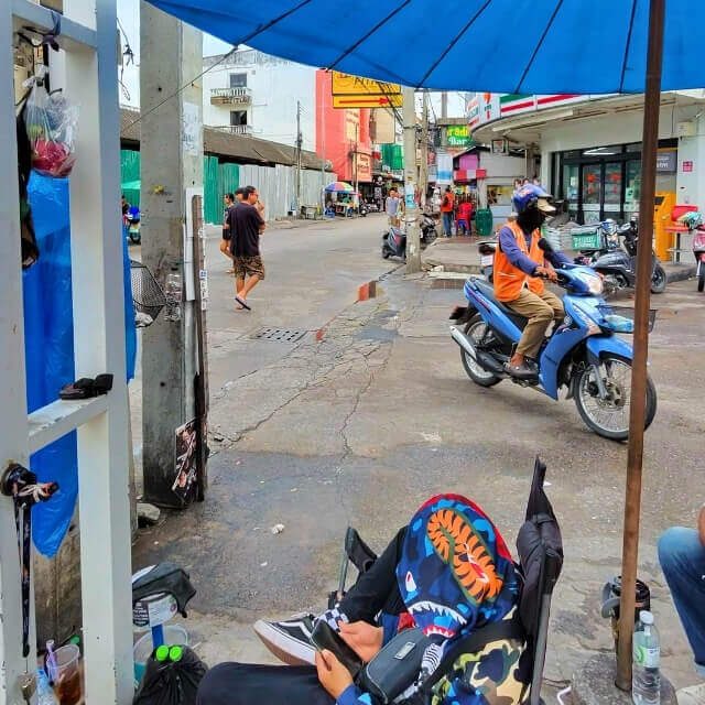 Alltag auf Pattayas Straßen Straßenszene in Pattaya mit Rollerfahrern und kleinen Geschäften