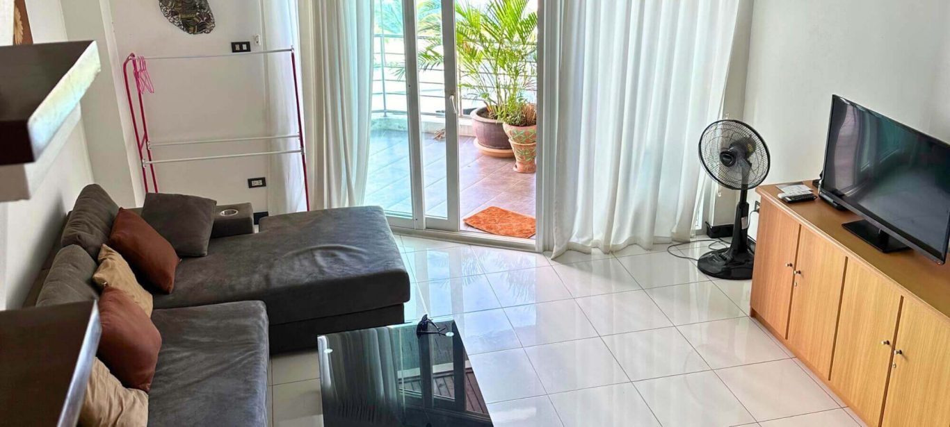 Helles Condo Wohnzimmer in Thailand mit Sofa, Balkon und Fernseher