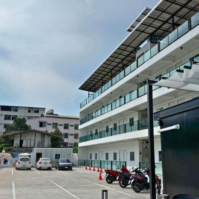 Modernes Hotel in Pattaya mit Balkonen, Parkplatz und abgestellten Scootern