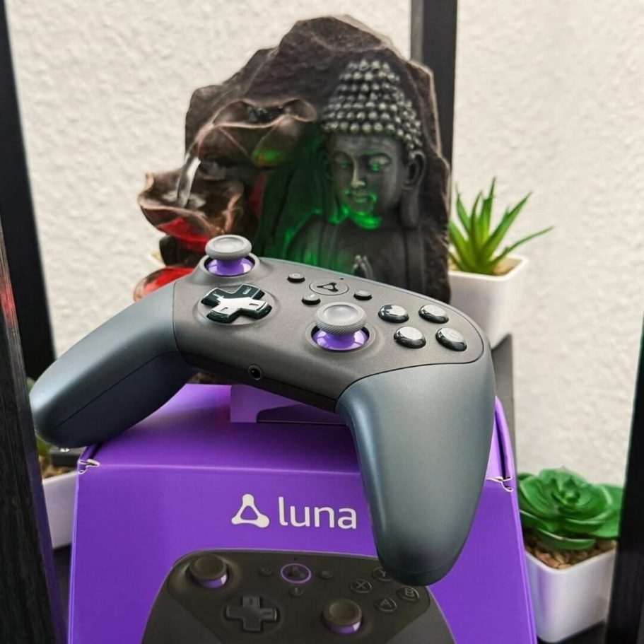 Amazon Luna Controller auf lilafarbener Verpackung mit Buddha-Deko und Pflanzen im Hintergrund -Fotoaufnahme