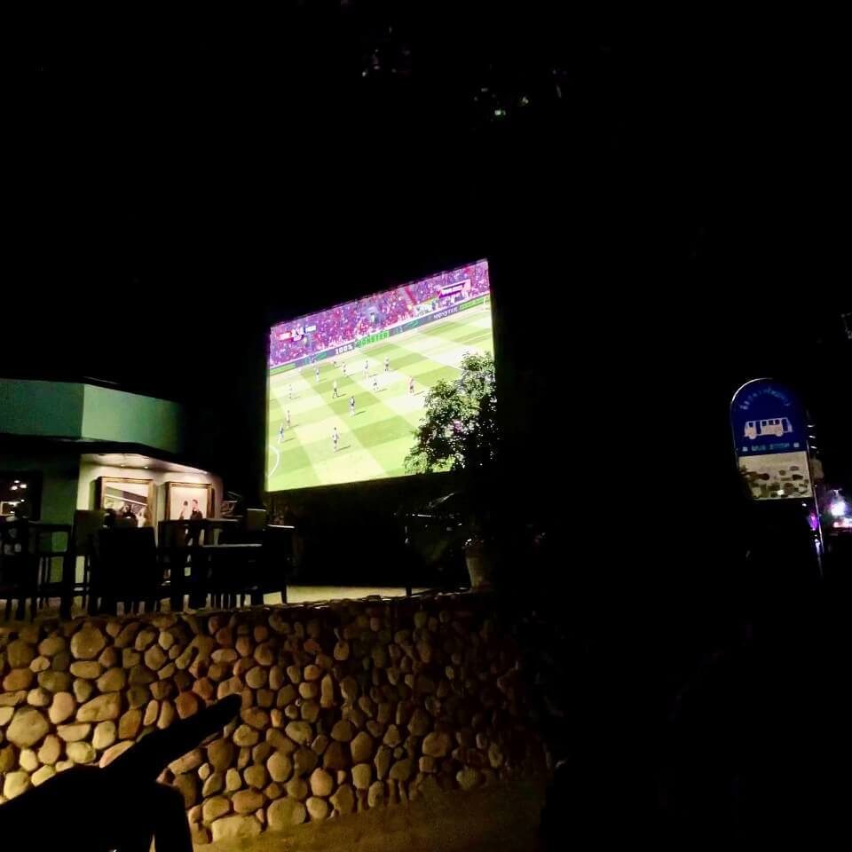 Fußballspiel auf einem großen Außenbildschirm in Pattaya bei Nacht