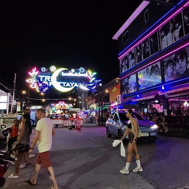 Tree Town Pattaya bei Nacht mit beleuchteten Bars, Besuchern und Straßenverkehr