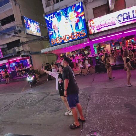 Soi 6 in Pattaya bei Nacht mit beleuchteten Bars, Schildern und Menschen auf der Straße