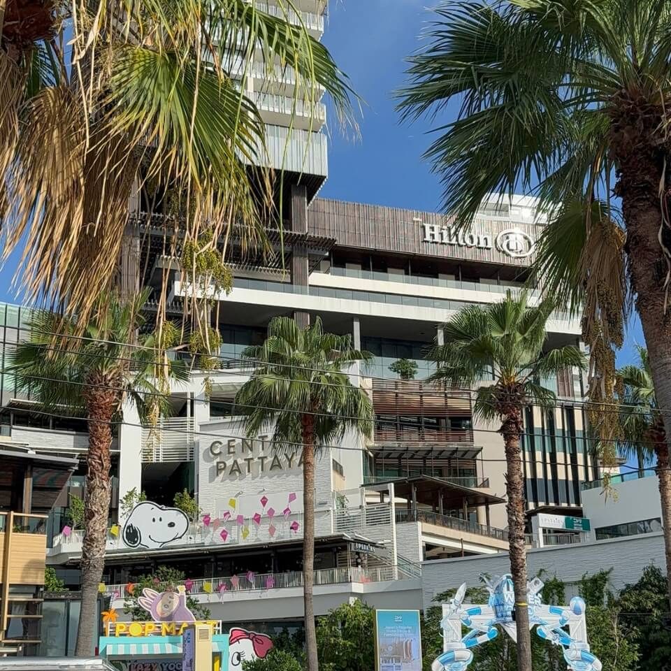 Hilton Hotel in Central Pattaya an der Beach Road mit Palmen und Einkaufszentrum im Vordergrund