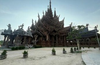 Luftaufnahme des Sanctuary of Truth in Pattaya, umgeben von Meer und Stadt-Skyline.