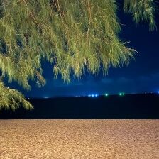 Na Jomtien Beach bei Nacht mit dunklem Strand, Meer und Lichtern in der Umgebung