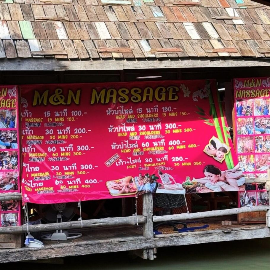 M&N Massage im Floating Market: Preisschild mit Thai-Massageangeboten von 100-400 Baht, zweisprachig in Thai und Englisch.