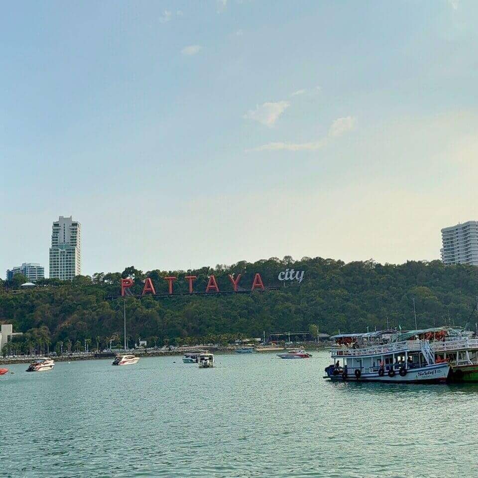 Pattaya City Sign an der Bucht Pattaya City Sign an der Bucht mit Booten auf dem Wasser