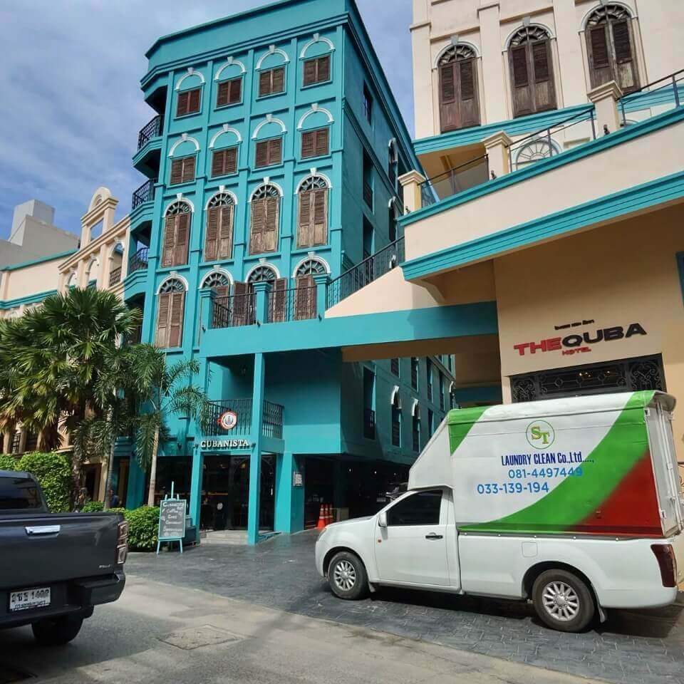 Hotelgebäude mit Lieferfahrzeug und weiteren Fahrzeugen vor dem Eingang