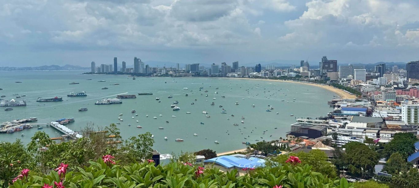 Blick über die Bucht von Pattaya mit Stadt, Strand und zahlreichen Booten im Wasser