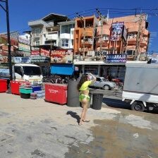 Frau an der Pattaya Beach Road mit Palmen, Straße und Gebäuden im Hintergrund