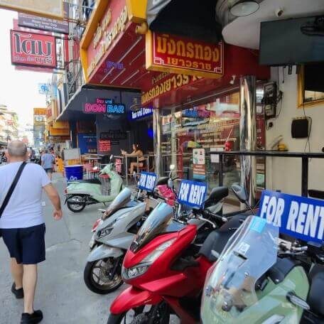 Soi Buakhao Pattaya bei Tag Straßenszene in der Soi Buakhao mit Rollerverleih, Geschäften und Bars entlang des Gehwegs