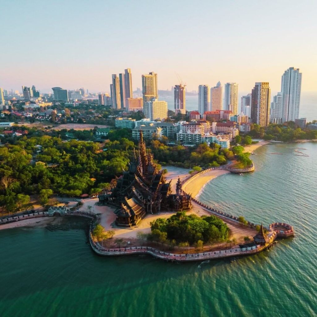 Sanctuary of Truth in Pattaya, Thailand – Ein beeindruckender Holztempel am Meer mit der Skyline von Pattaya im Hintergrund.