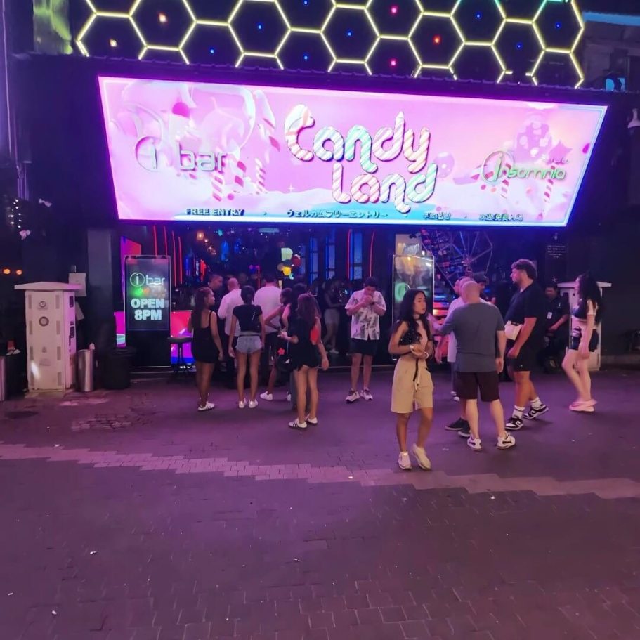 Nachtaufnahme der Walking Street mit Candy Land 
Themenabend bei iBar und Insomnia. Pinke Leuchtreklame über dem Eingang, Besucher davor. 