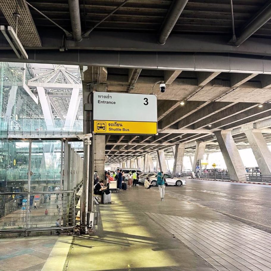 Eingang 3 am Flughafen Suvarnabhumi in Bangkok, Thailand, mit Shuttlebus-Hinweis. Moderner internationaler Flughafen.