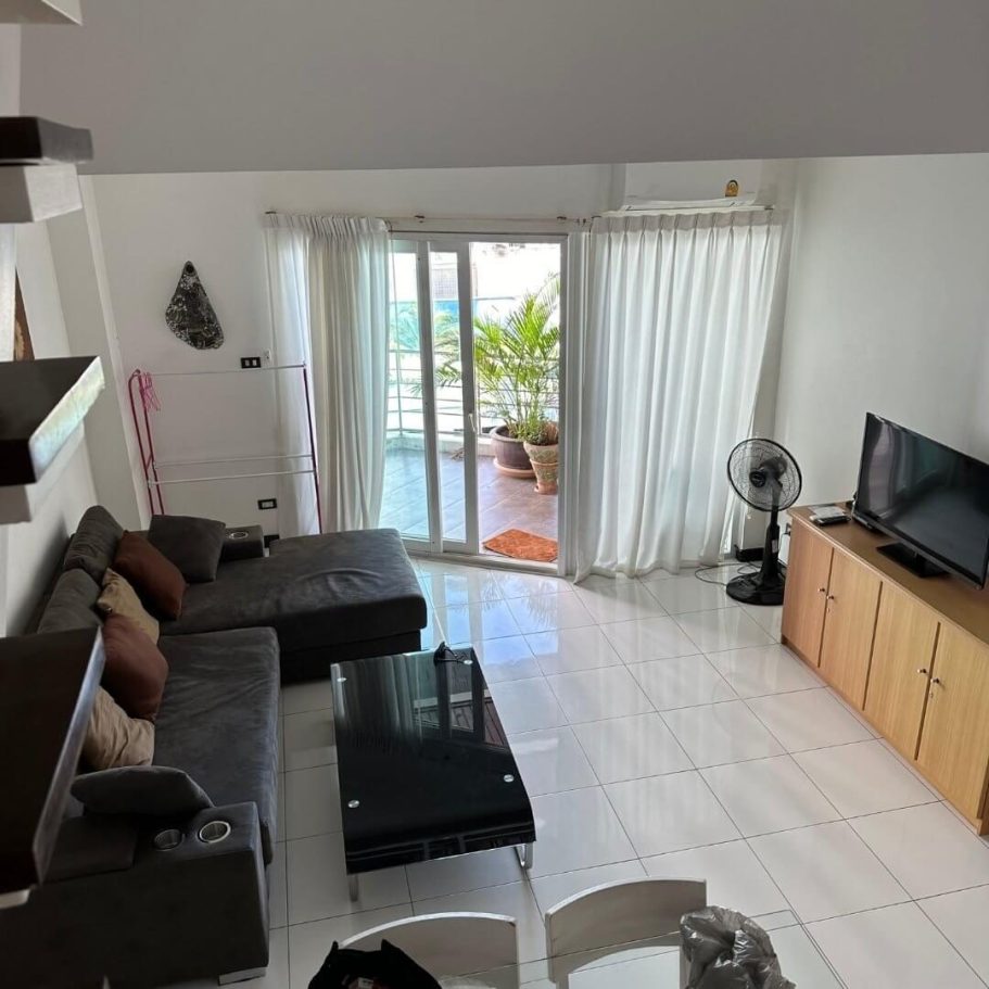 Modernes Hotelzimmer mit Sofa, Fernseher und Balkon – ideal für entspanntes Cloud-Gaming