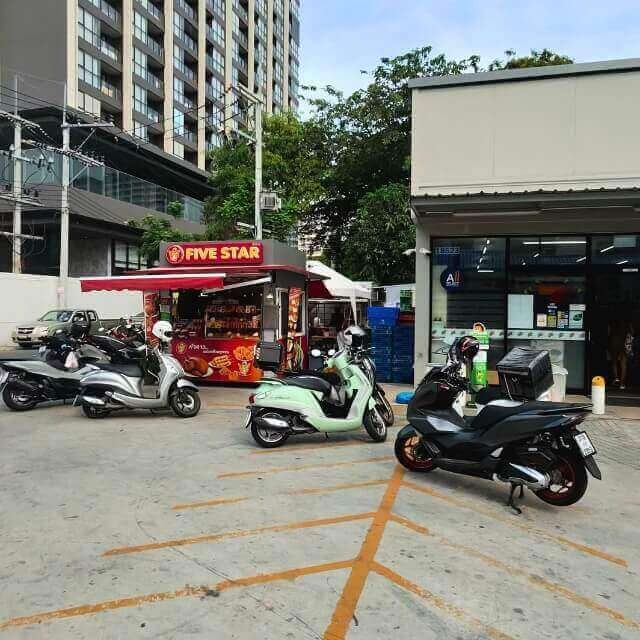 Mehrere Roller stehen vor einem 7-Eleven und einem Five Star Imbiss in Pattaya