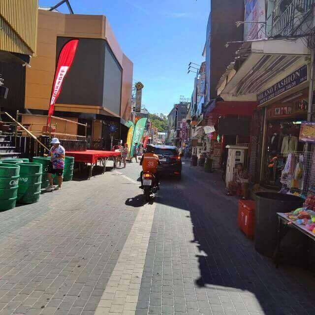 Walking Street in Pattaya tagsüber mit Auto und Motorrad