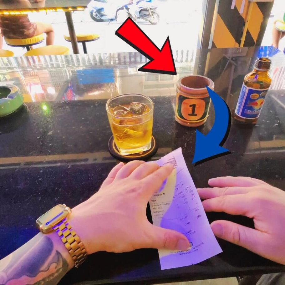 Pattaya Bar Rechnung im Holzbecher Glas mit Vodka-Energy-Gemisch, Holzbecher mit Nummer 1 und Rechnung auf einer Bar in Pattaya