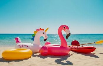 Bunte Schwimmreifen am Strand von Koh Larn, Pattaya, mit türkisfarbenem Meer im Hintergrund.