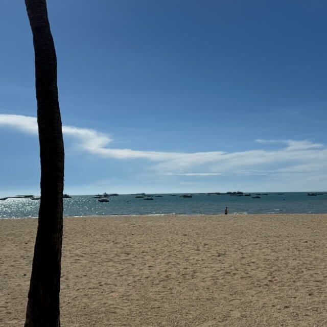 Pattaya Beach bei leicht bewölktem Wetter Pattaya Beach mit Sandstrand, Meer und Booten bei leicht bewölktem Himmel