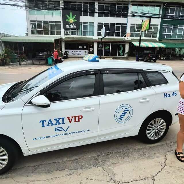VIP Taxi in Pattaya Weißes VIP-Taxi mit Taxischild und Firmenlogo am Straßenrand