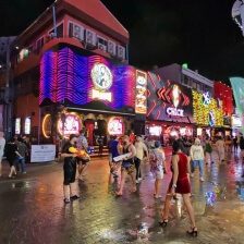 Songkran Feier bei Nacht auf der Walking Street in Pattaya mit Wasserpistolen und Menschen auf der Straße